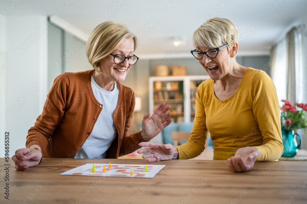 two senior women friends or sisters play leisure board game at home two senior women friends or sisters play leisure board game at home