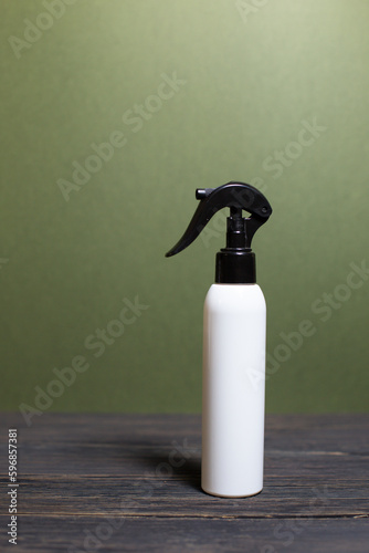 A white bottle with a black sprayer on a beautiful background, spray