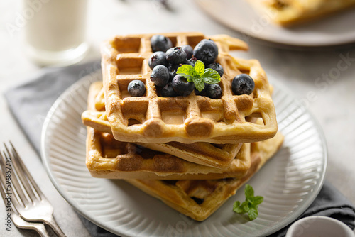 Homemade belgian waffles with blueberries and honey