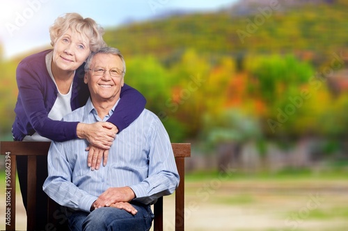 Elderly, happy couple on wooden bench in garden © BillionPhotos.com