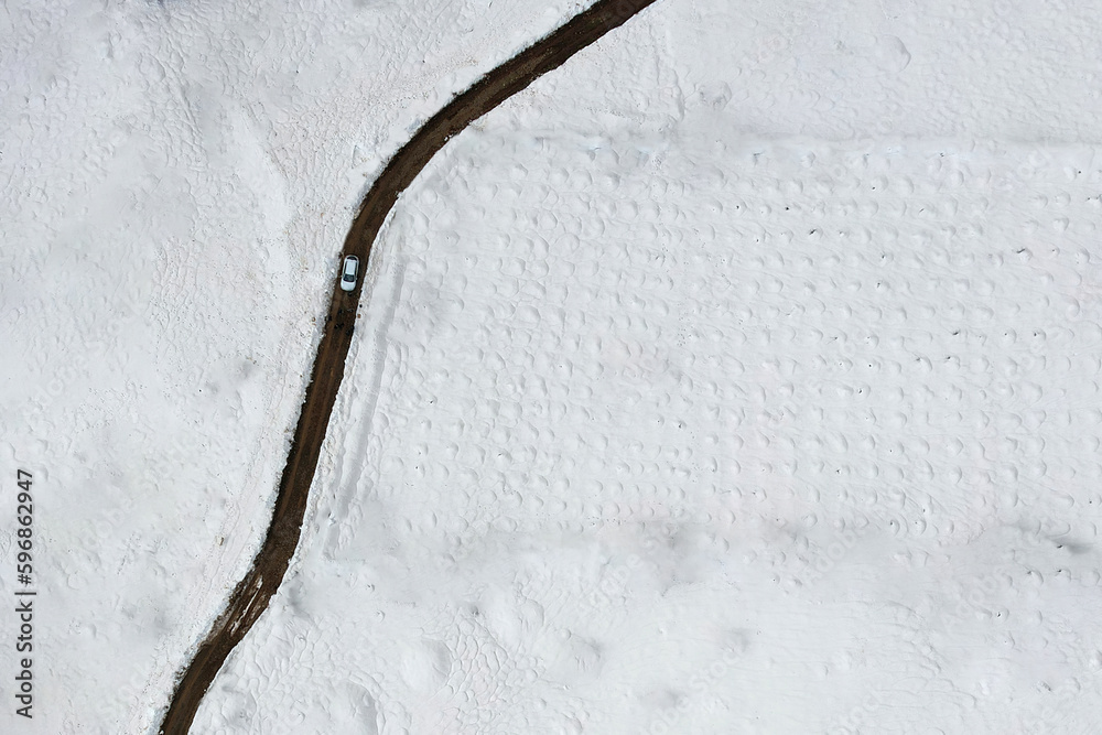 asphalt road on a snowy day, shot with drone, aerial shot, minimal photography