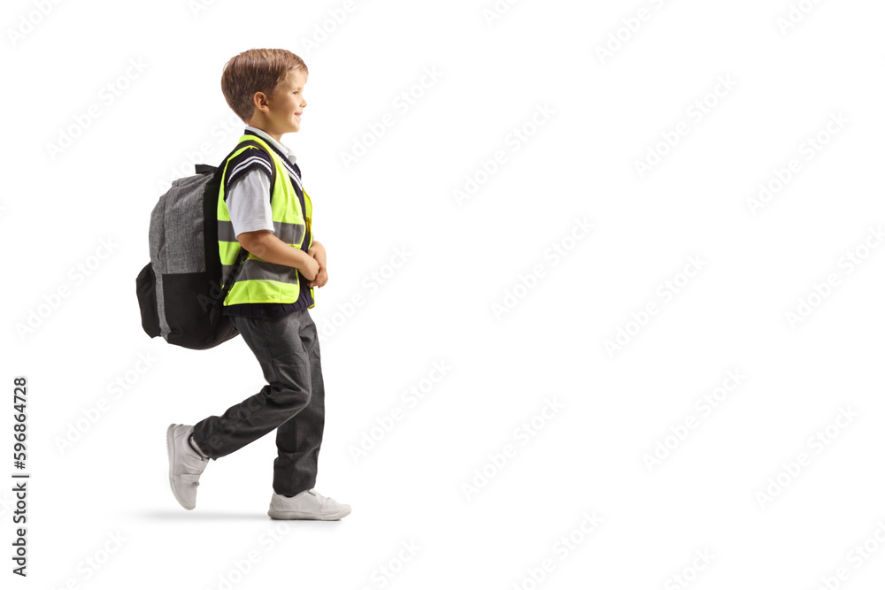 Full length profile shot of a schoolboy wearing a yellow safety vest and walking Full length profile shot of a schoolboy wearing a yellow safety vest and walking
