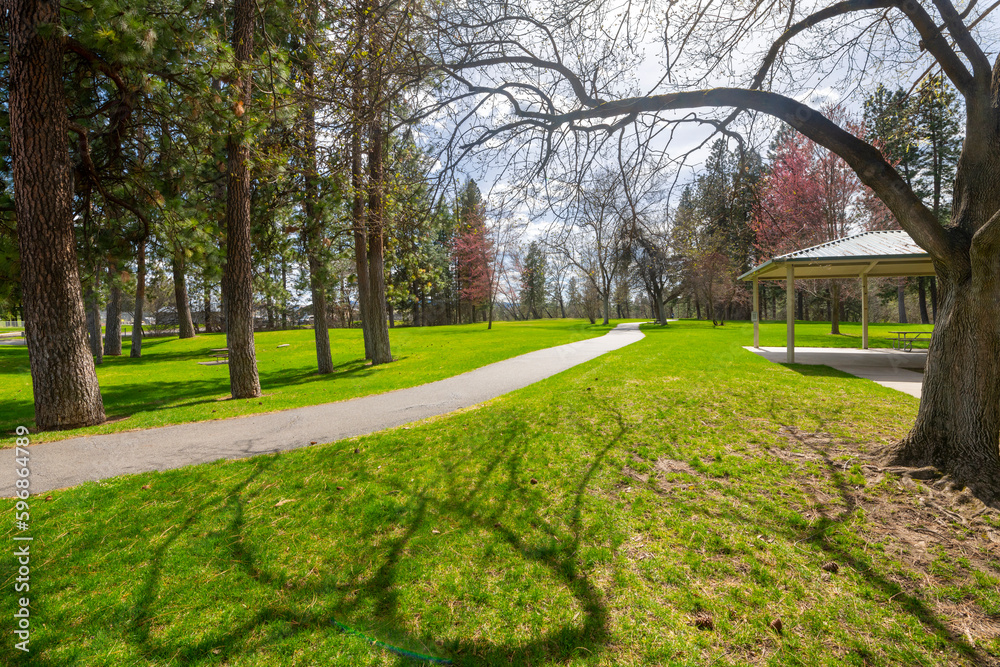 Paved walking trails through the grassy areas, beaches, gazebos and woods at the riverfront Plante's Ferry Park along the banks of the Spokane River in Spokane Valley, Washington, USA. 