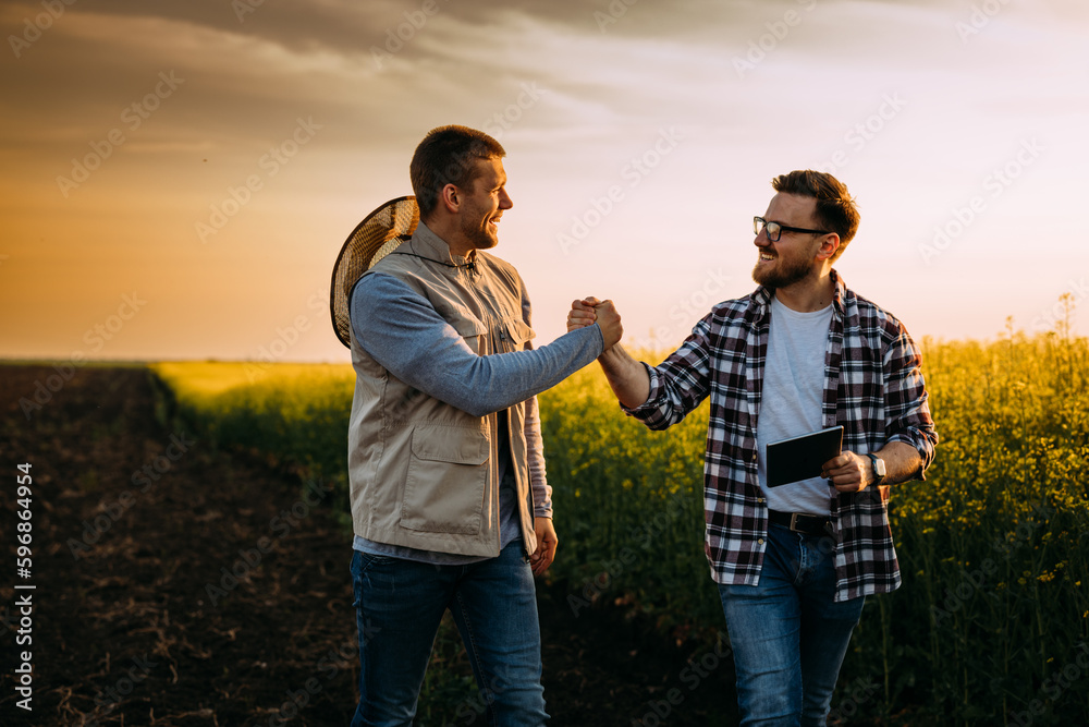 A Farmer and his business partner greet each other on the field A Farmer and his business partner greet each other on the field
