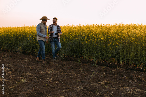 Two farmers discussing business while taking a walk on their filled.