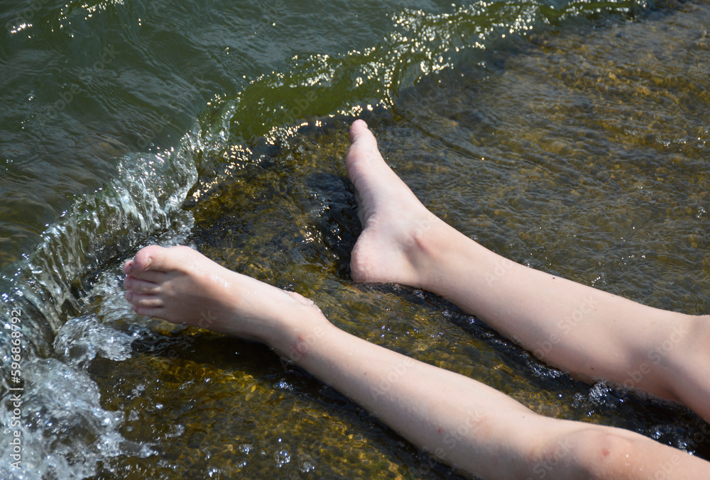 female-feet-on-a-stone-are-washed-by-sea-water-sunbathing-and-washing