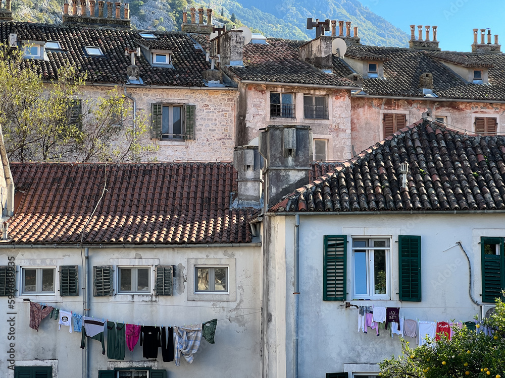 Old multi-storey houses with tiled roofs and clothes drying on clotheslines