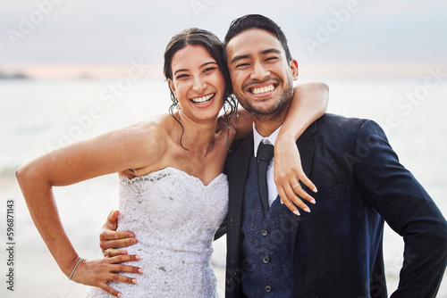 For better or worse, in sickness and health, for richer or poorer. Shot of a young couple on the beach on their wedding day. photo