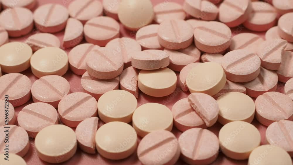 Pink pills and a stethoscope on a pink background. Medical tablets. Pills close-up. Pink pills and a stethoscope on a pink background. Medical tablets. Pills close-up.
