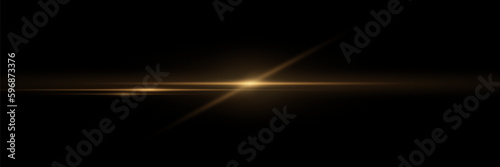 Golden glitter of light. Bright light effect with rays and glare. On a black background.
