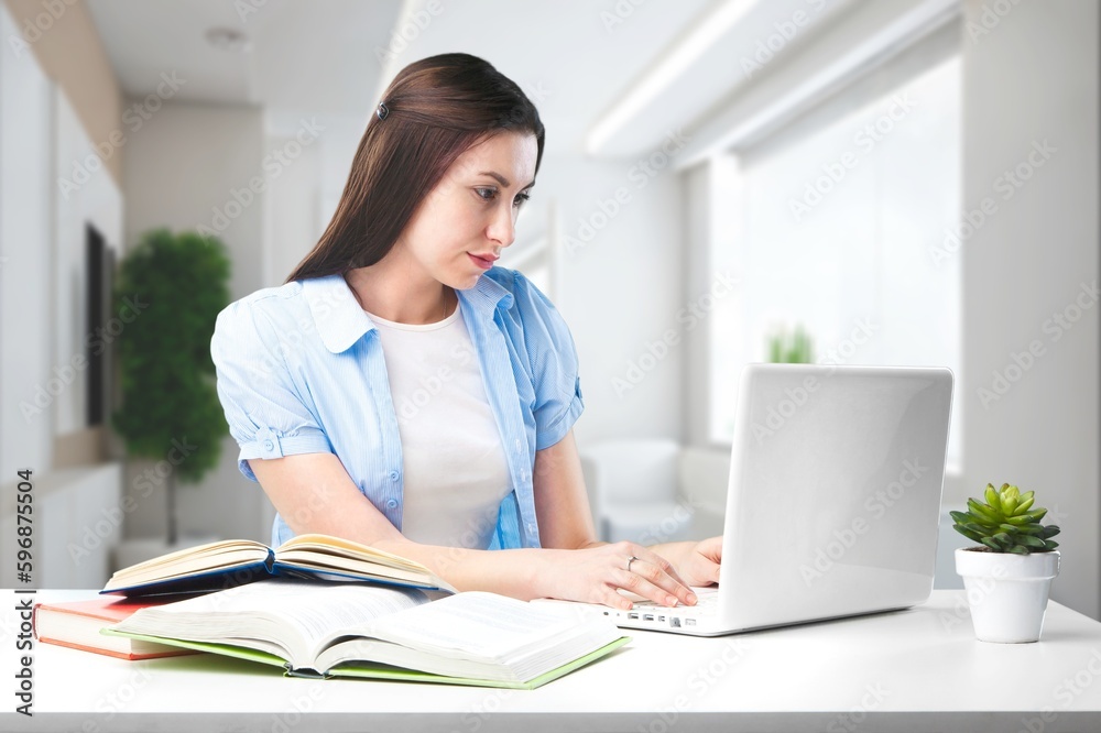 Young happy business woman works on computer