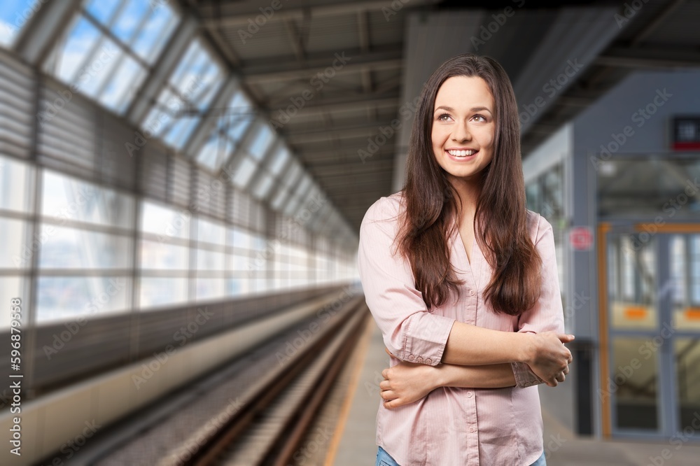 Happy young woman going on train station Happy young woman going on train station