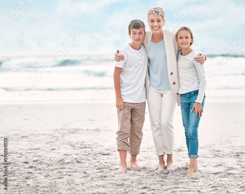 Lighting makes the picture. Shot of a mature woman and her grandchildren bonding at the beach.