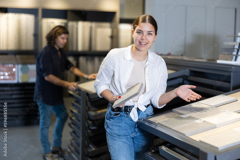 Confident female customer picking out wall tile materials for bathroom in hardware store