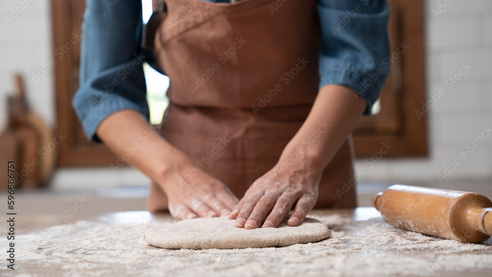 Woman hands kneading dough in the kitchen