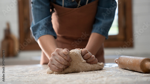 Woman hands kneading dough in the kitchen photo