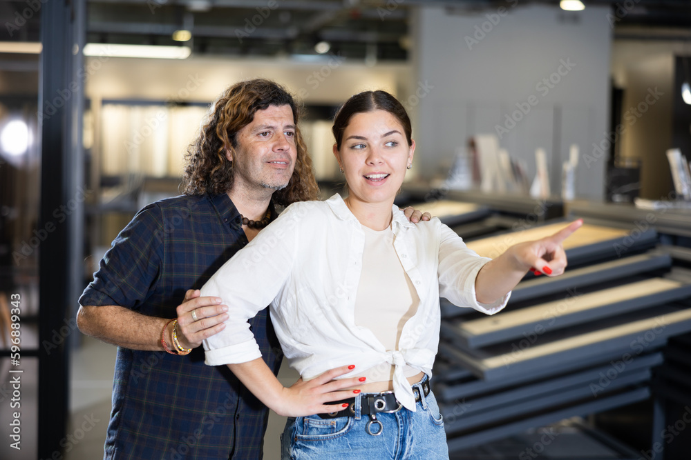 Woman and man points his hand at something in a hardware store