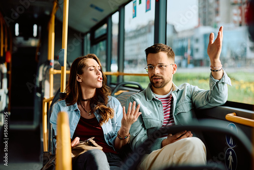 Quadro em tela Young couple arguing while riding in bus.