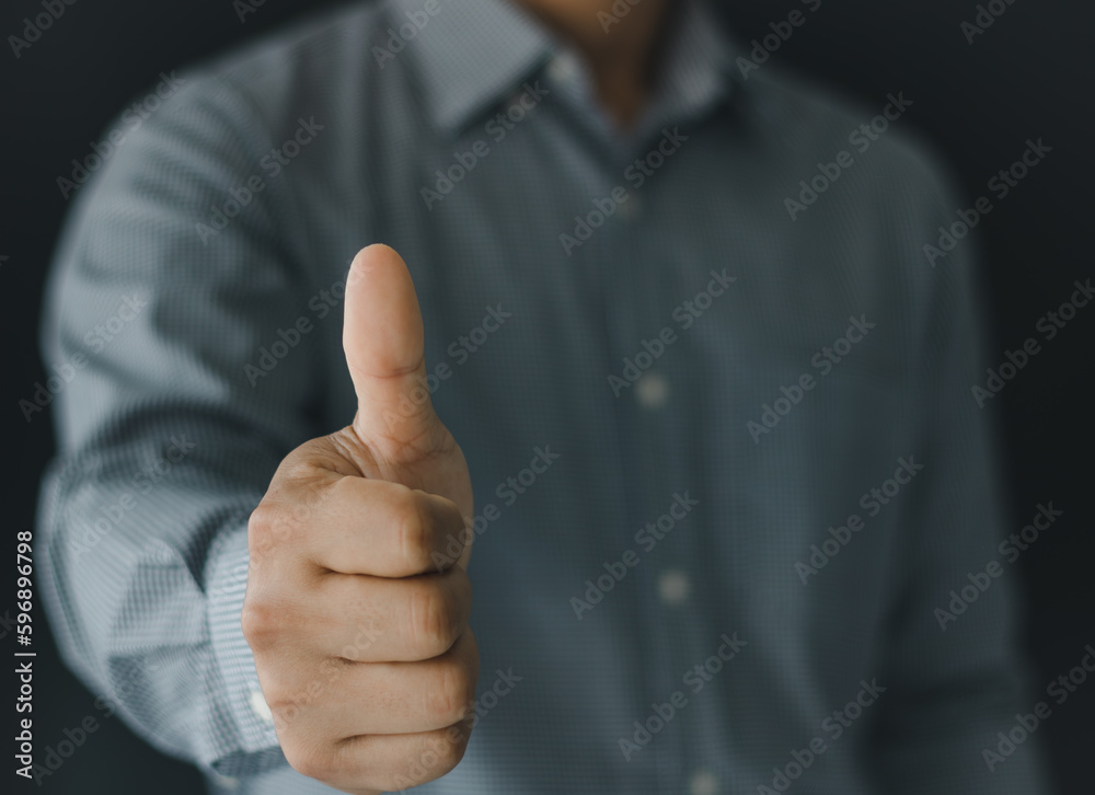 Close up of businessman showing raised thumbs at the camera as a gesture of recommendation or good choice. Professional support and service team demonstrates satisfaction and gives a positive response Close up of businessman showing raised thumbs at the camera as a gesture of recommendation or good choice. Professional support and service team demonstrates satisfaction and gives a positive response