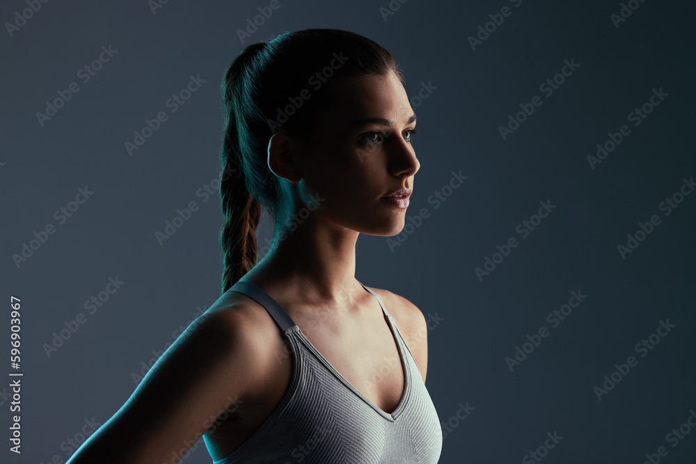Staying in shape. Cropped shot of an attractive young female athlete posing in studio against a grey background. Staying in shape. Cropped shot of an attractive young female athlete posing in studio against a grey background.