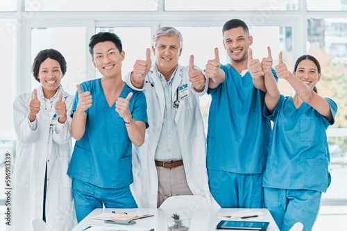 As confident as they are capable. Portrait of a group of medical practitioners showing thumbs up together in a medical office.