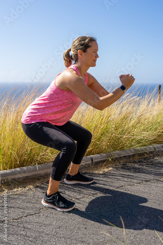 Fototapeta Naklejka Na Ścianę i Meble -  side view of a woman doing squats