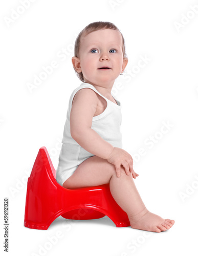 Little child sitting on baby potty against white background