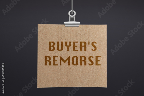 Text Buyer's Remorse on hanging poster against dark grey wall