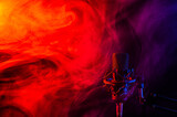 Professional microphone in red blue smoke on a black background.