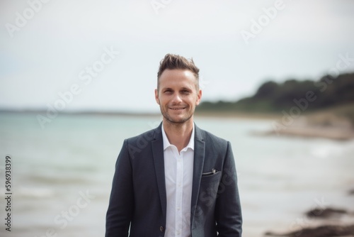 Portrait of a handsome young man in a suit on the beach