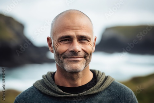 Portrait of smiling mature man standing by the sea on a sunny day