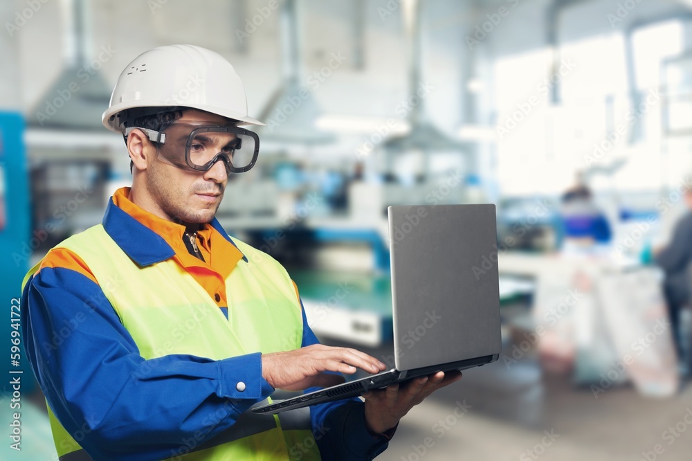 Portrait of smart engineer wearing safety helmet use laptop computer Portrait of smart engineer wearing safety helmet use laptop computer