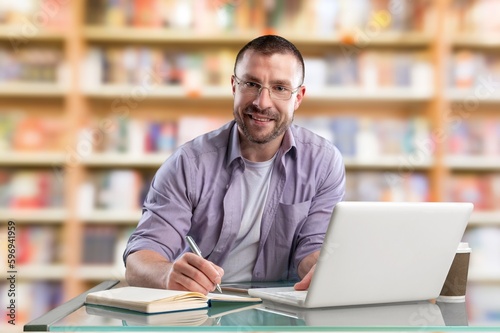 Happy professional young business man on library background