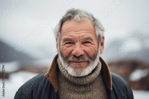 Portrait of an elderly man with gray beard and mustache in the mountains