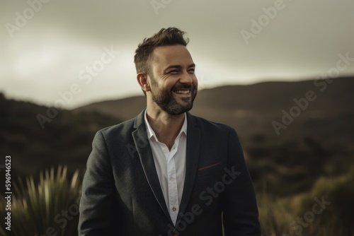 Portrait of a handsome young man in a suit on a background of mountains