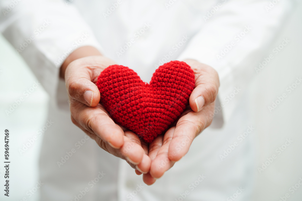 Asian woman doctor holding red heart for health in hospital. Asian woman doctor holding red heart for health in hospital.