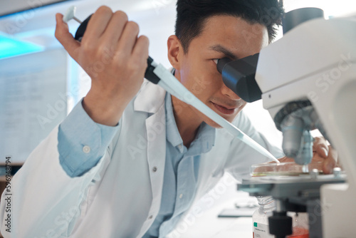 Even the slightest twitch could be a problem. Shot of a male lab tech filling a petri dish underneath a microscope.