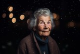 Portrait of an elderly woman at night in the rain. Selective focus.