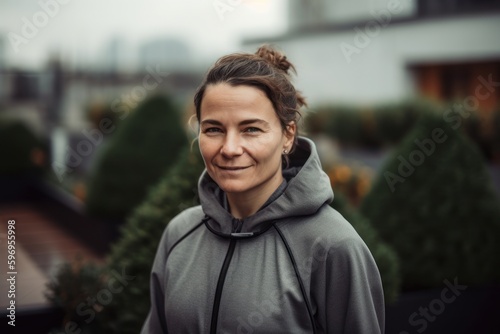 Portrait of a beautiful middle-aged woman in a gray hoodie.