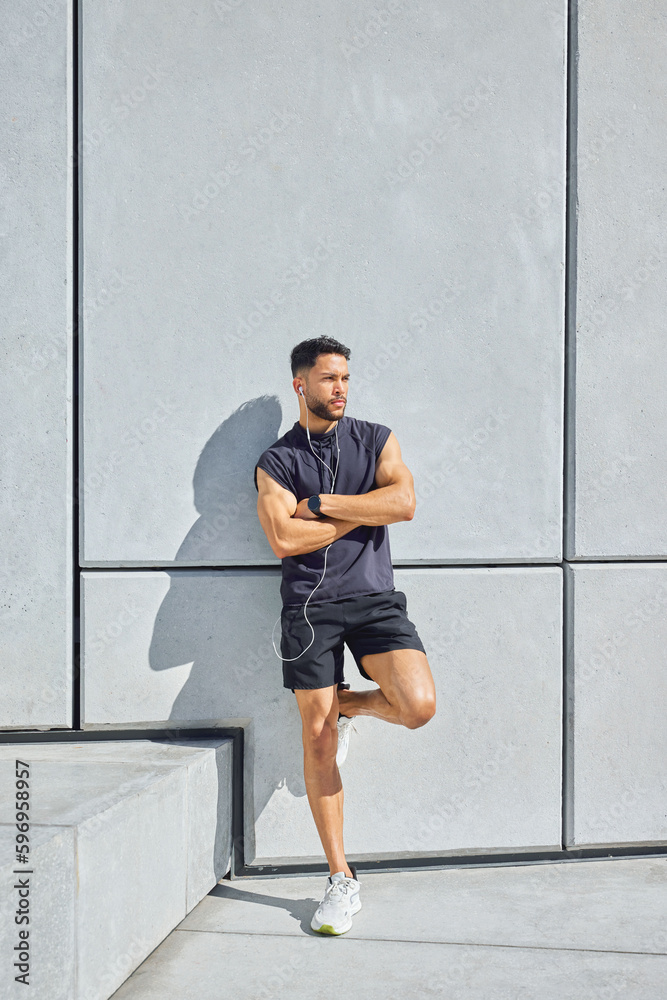Success at anything always comes down to focus and effort. Shot of a sporty young man listening to music and standing with his arms crossed while exercising outdoors. Success at anything always comes down to focus and effort. Shot of a sporty young man listening to music and standing with his arms crossed while exercising outdoors.