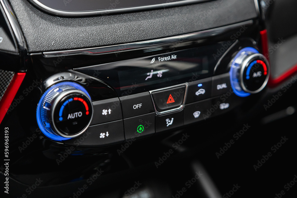 Modern black car interior: climat control view with air conditioning button, the dashboard with information about temperature inside a car