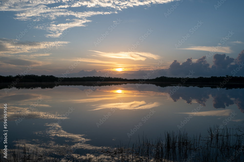 Obraz premium Colorful sunrise cloudscape reflected in calm water of Nine Mile Pond in Everglades National Park, Florida.