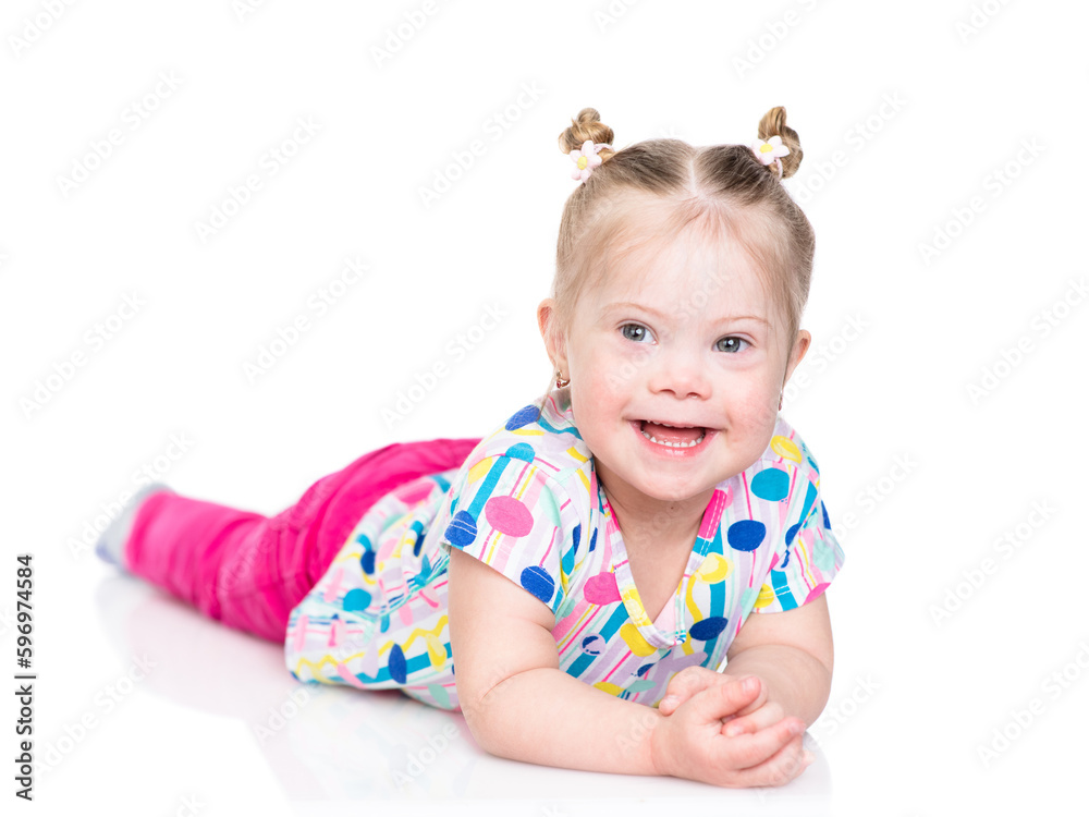 Happy little girl with Downs syndrom lying on floor. Isolated on white background Happy little girl with Downs syndrom lying on floor. Isolated on white background