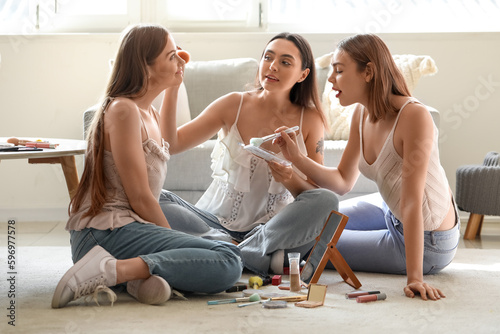 Young women doing makeup at home