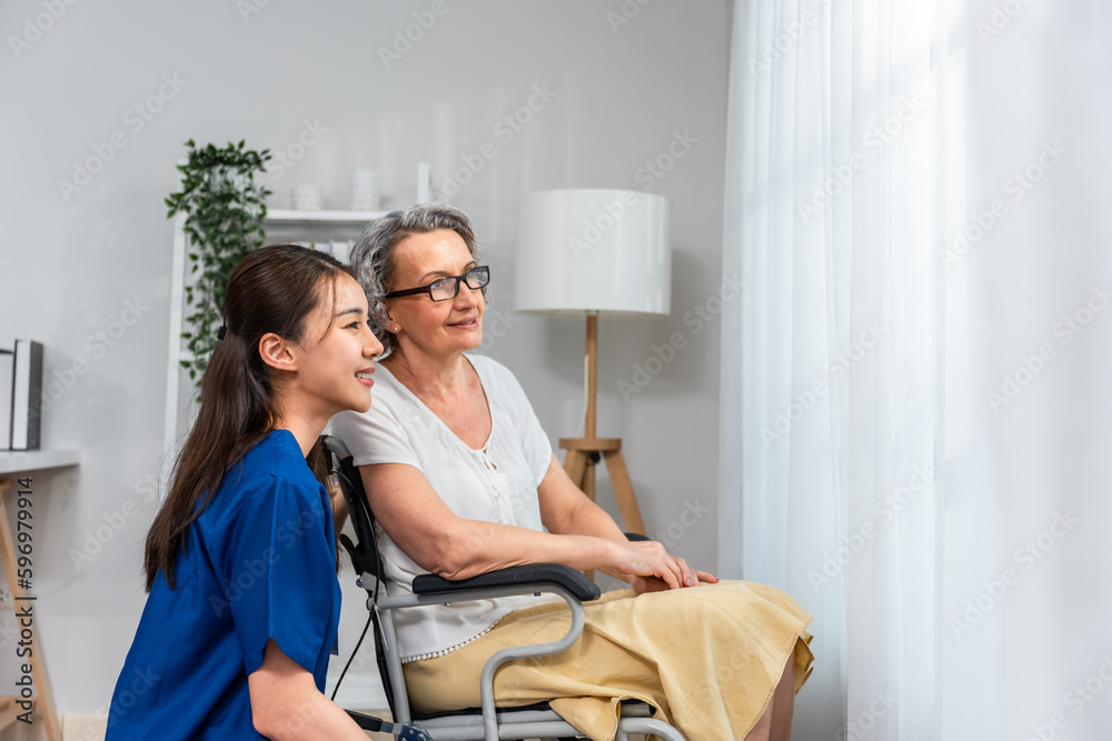 Caucasian senior woman sit on wheelchair with young Asian nurse at home. Caucasian senior woman sit on wheelchair with young Asian nurse at home.