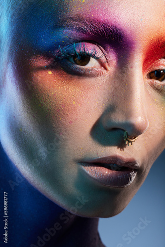 Colour outside the lines. Studio shot of a young woman posing with multi-coloured paint on her face.