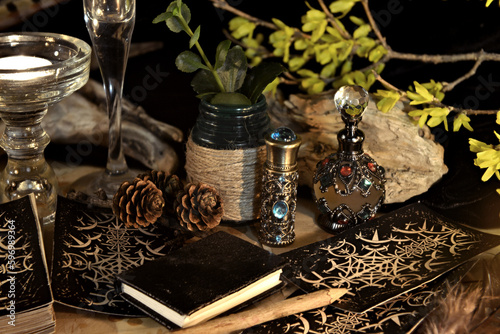 Esoteric and occult still life with vintage magic objects, tarot cards, book and candle on witch table altar for mystic rituals and fortune telling. Halloween and gothic background