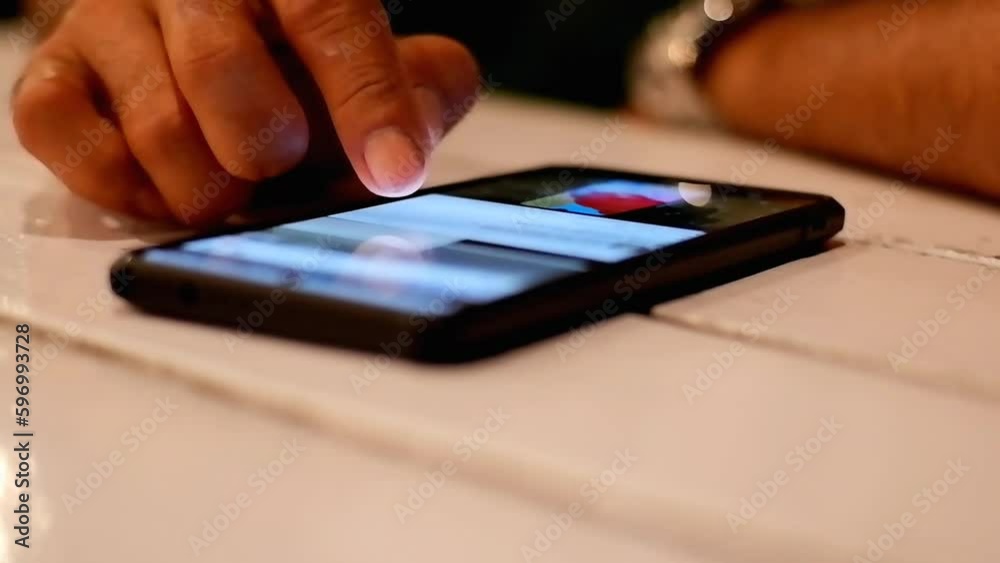 a man scrolling the smartphone screen on the table a man scrolling the smartphone screen on the table