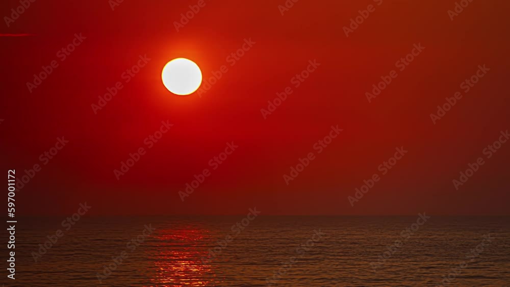 Timelapse of glowing red sunrise over water Timelapse of glowing red sunrise over water