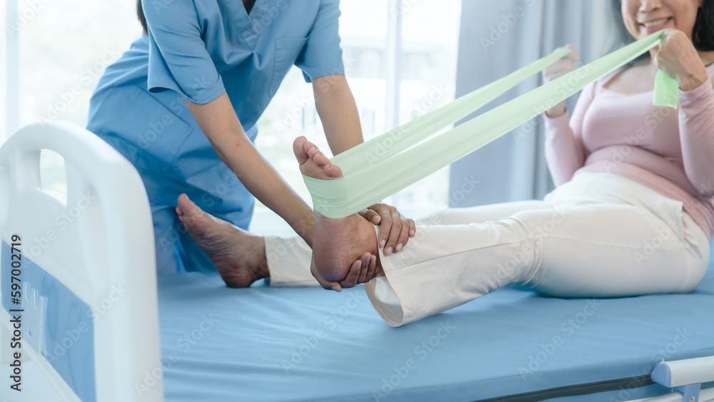 Asian Chinese female physiotherapist caregiver helping elderly woman exercise for recovery, prevention of osteoarthritis and osteoporosis. Asian Chinese female physiotherapist caregiver helping elderly woman exercise for recovery, prevention of osteoarthritis and osteoporosis.